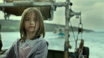 Movie still from “Ondine” (2009), directed by Neil Jordan – A young girl standing in front of a body of water; Close Up shot, Low angle