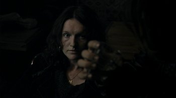 Movie still from “Ondine” (2009), directed by Neil Jordan – A woman holding a gun in a dark room; Close Up shot, Over the shoulder angle