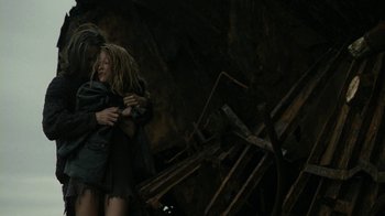 Movie still from “Ondine” (2009), directed by Neil Jordan – Two people hugging in a dark room with a pile of debris; Medium shot, Low angle
