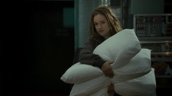 Movie still from “Ondine” (2009), directed by Neil Jordan – A woman is holding a pillow in her arms; Medium shot, Over the shoulder angle