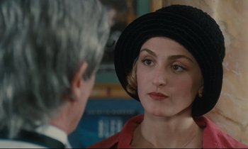 Movie still from “One Hundred and One Nights” (1995), directed by Agnès Varda – A woman wearing a black hat looking at a man in a black hat; Close Up shot, Over the shoulder angle