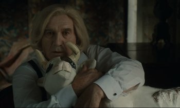 Movie still from “One Hundred and One Nights” (1995), directed by Agnès Varda – An older man holding a stuffed animal in his lap; Close Up shot, Low angle