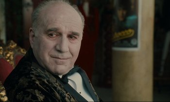 Movie still from “One Hundred and One Nights” (1995), directed by Agnès Varda – An older man wearing a suit and tie; Close Up shot, Low angle