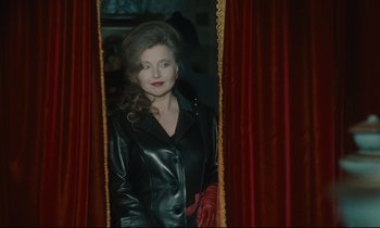 Movie still from “One Hundred and One Nights” (1995), directed by Agnès Varda – A woman wearing a leather jacket looking into a mirror; Medium shot, Over the shoulder angle