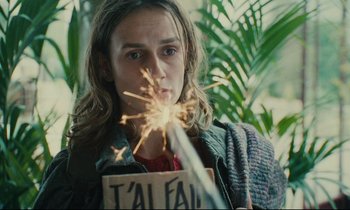 Movie still from “One Hundred and One Nights” (1995), directed by Agnès Varda – A person holding a sparkler in their hand; Close Up shot, Over the shoulder angle