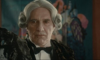 Movie still from “One Hundred and One Nights” (1995), directed by Agnès Varda – An old man with grey hair wearing a bow tie; Close Up shot, Low angle