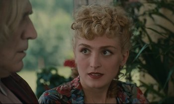 Movie still from “One Hundred and One Nights” (1995), directed by Agnès Varda – A person wearing a floral shirt; Close Up shot, Over the shoulder angle