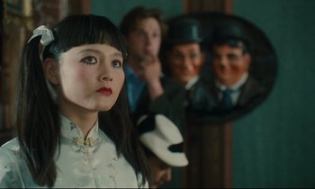 Movie still from “One Hundred and One Nights” (1995), directed by Agnès Varda – A woman standing in front of a group of people; Close Up shot, Over the shoulder angle