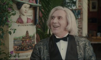 Movie still from “One Hundred and One Nights” (1995), directed by Agnès Varda – A man in a suit and bow tie; Close Up shot, Over the shoulder angle