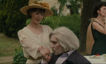 Movie still from “One Hundred and One Nights” (1995), directed by Agnès Varda – A woman standing next to a man in a suit; Medium shot, Over the shoulder angle