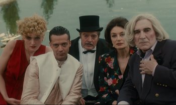 Movie still from “One Hundred and One Nights” (1995), directed by Agnès Varda – A group of people sitting next to a body of water; Medium shot, High angle