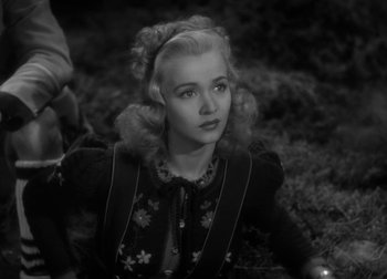 Movie still from “One Million B.C.” (1940), directed by Hal Roach Jr. – A woman with blonde hair sitting on the ground; Close Up shot, High angle