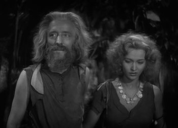 Movie still from “One Million B.C.” (1940), directed by Hal Roach Jr. – A man and a woman standing next to each other in front of trees; Medium shot, Over the shoulder angle