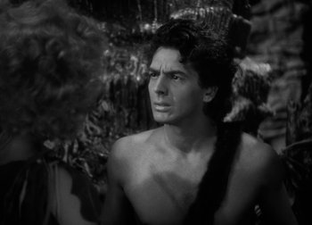 Movie still from “One Million B.C.” (1940), directed by Hal Roach Jr. – Black and white photograph of a shirtless man in a jungle setting; Close Up shot, Over the shoulder angle