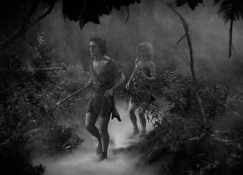 Movie still from “One Million B.C.” (1940), directed by Hal Roach Jr. – A man and a woman walking through the woods; Wide shot, High angle