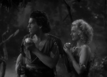Movie still from “One Million B.C.” (1940), directed by Hal Roach Jr. – A man and a woman are holding apples; Medium shot, High angle