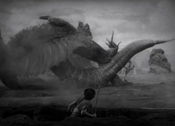 Movie still from “One Million B.C.” (1940), directed by Hal Roach Jr. – A man that is sitting in the water next to a monster; Extreme Wide shot, High angle