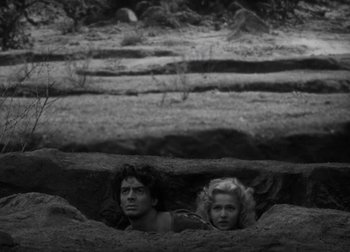 Movie still from “One Million B.C.” (1940), directed by Hal Roach Jr. – A man and a woman are in a cave; Wide shot, High angle