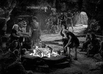 Movie still from “One Million B.C.” (1940), directed by Hal Roach Jr. – A black and white photo of people around a fire pit; Wide shot, High angle