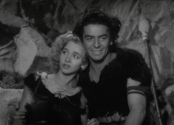 Movie still from “One Million B.C.” (1940), directed by Hal Roach Jr. – A man and a woman posing for a picture; Medium shot, Low angle