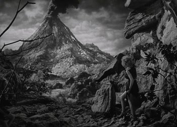 Movie still from “One Million B.C.” (1940), directed by Hal Roach Jr. – A black - and - white photo of a man holding a dragon; Extreme Wide shot, High angle