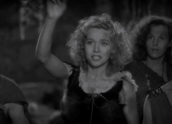 Movie still from “One Million B.C.” (1940), directed by Hal Roach Jr. – A black - and - white photo of a woman with curly blonde hair; Medium shot, Over the shoulder angle