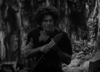 Movie still from “One Million B.C.” (1940), directed by Hal Roach Jr. – A black - and - white photo of a man holding a spear; Medium shot, High angle