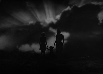 Movie still from “One Million B.C.” (1940), directed by Hal Roach Jr. – A black and white photo of a woman and a man and a child; Extreme Wide shot, Low angle