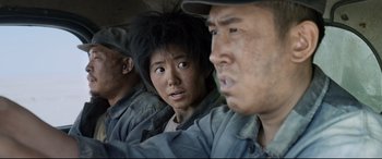 Movie still from “One Second” (2020), directed by Yimou Zhang – A group of people sitting next to each other; Close Up shot, Over the shoulder angle