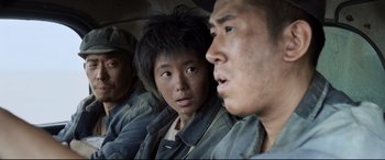 Movie still from “One Second” (2020), directed by Yimou Zhang – A group of young men sitting next to each other; Close Up shot, Over the shoulder angle