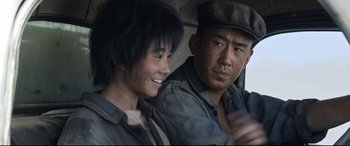 Movie still from “One Second” (2020), directed by Yimou Zhang – A man and a woman sitting next to each other in a car; Close Up shot, Over the shoulder angle