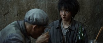 Movie still from “One Second” (2020), directed by Yimou Zhang – A man and a woman standing next to each other; Close Up shot, Over the shoulder angle