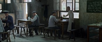 Movie still from “One Second” (2020), directed by Yimou Zhang – A group of men sitting at a table drinking beer; Wide shot, High angle