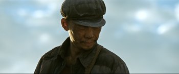 Movie still from “One Second” (2020), directed by Yimou Zhang – A person wearing a hat; Close Up shot, Low angle