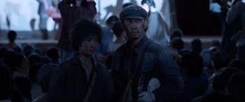 Movie still from “One Second” (2020), directed by Yimou Zhang – A man and a woman standing next to each other; Medium shot, Low angle