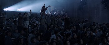 Movie still from “One Second” (2020), directed by Yimou Zhang – A group of people sitting in a dark room; Wide shot, High angle