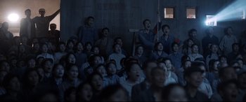 Movie still from “One Second” (2020), directed by Yimou Zhang – A group of people sitting in front of a window; Wide shot, High angle