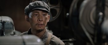 Movie still from “One Second” (2020), directed by Yimou Zhang – A person wearing a hat; Close Up shot, Low angle