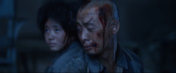 Movie still from “One Second” (2020), directed by Yimou Zhang – A man with blood all over his face and head; Close Up shot, Over the shoulder angle