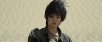 Movie still from “One Second” (2020), directed by Yimou Zhang – A young person with a black hair style; Close Up shot, Low angle