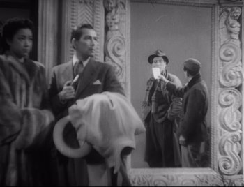 Movie still from “One Wonderful Sunday” (1947), directed by Akira Kurosawa – A group of people standing in front of a mirror; Medium shot, Over the shoulder angle