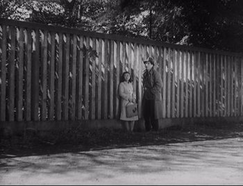 Movie still from “One Wonderful Sunday” (1947), directed by Akira Kurosawa – A man and a woman standing in front of a fence; Wide shot, Low angle