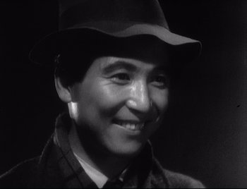Movie still from “One Wonderful Sunday” (1947), directed by Akira Kurosawa – A black and white photo of a person wearing a hat; Close Up shot, Low angle