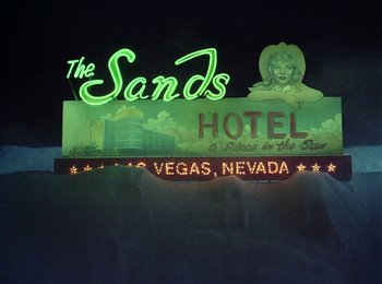 Movie still from “One from the Heart” (1981), directed by Francis Ford Coppola – A neon sign for the sands hotel and casino in las vegas , nevada; Wide shot, Low angle