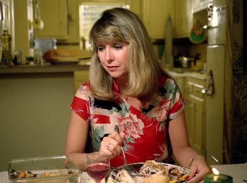 Movie still from “One from the Heart” (1981), directed by Francis Ford Coppola – A woman sitting at a table with a plate of food in front of her; Medium shot, High angle