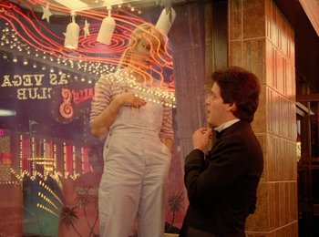 Movie still from “One from the Heart” (1981), directed by Francis Ford Coppola – A man and a woman standing next to each other in front of a neon sign; Medium shot, Low angle
