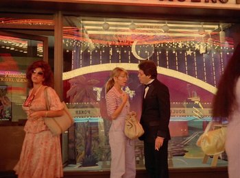 Movie still from “One from the Heart” (1981), directed by Francis Ford Coppola – A man and a woman standing in front of a building; Wide shot, Low angle