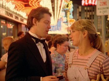 Movie still from “One from the Heart” (1981), directed by Francis Ford Coppola – A man and a woman talking to each other in front of a crowd; Medium shot, Over the shoulder angle