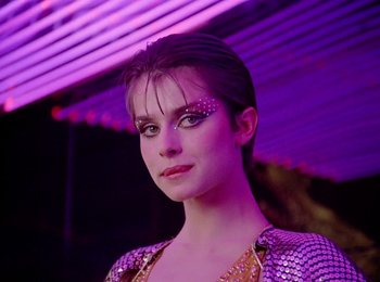 Movie still from “One from the Heart” (1981), directed by Francis Ford Coppola – A woman in a purple dress with a purple background; Close Up shot, Low angle