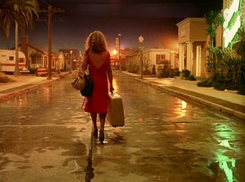 Movie still from “One from the Heart” (1981), directed by Francis Ford Coppola – A woman in a red dress walking down a street; Wide shot, High angle